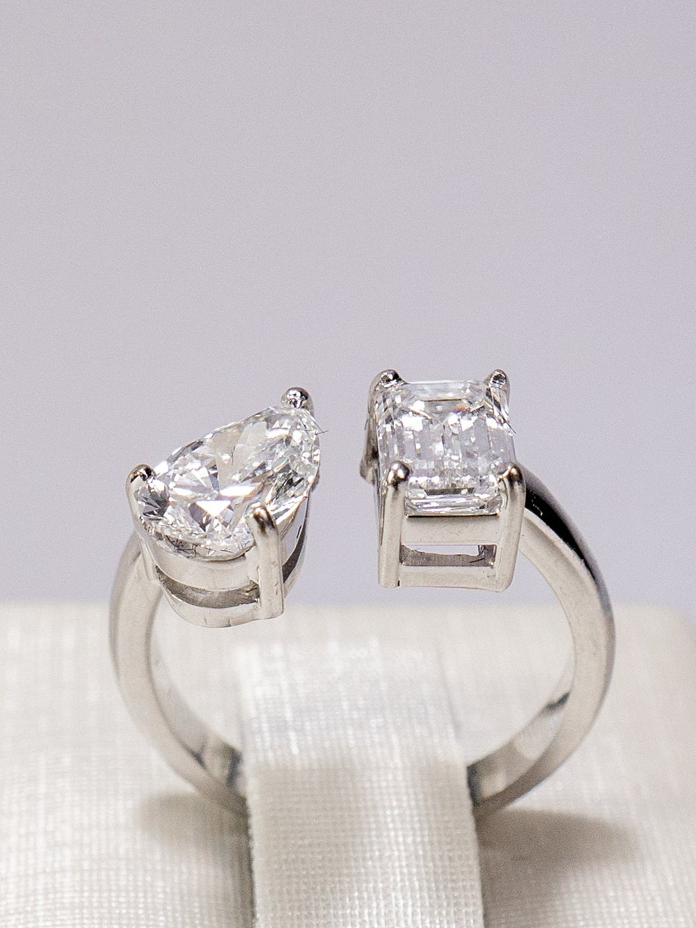 Anel Duo Pera e Esmeralda da ROCCA em detalhe, dois diamantes em garras de ouro branco