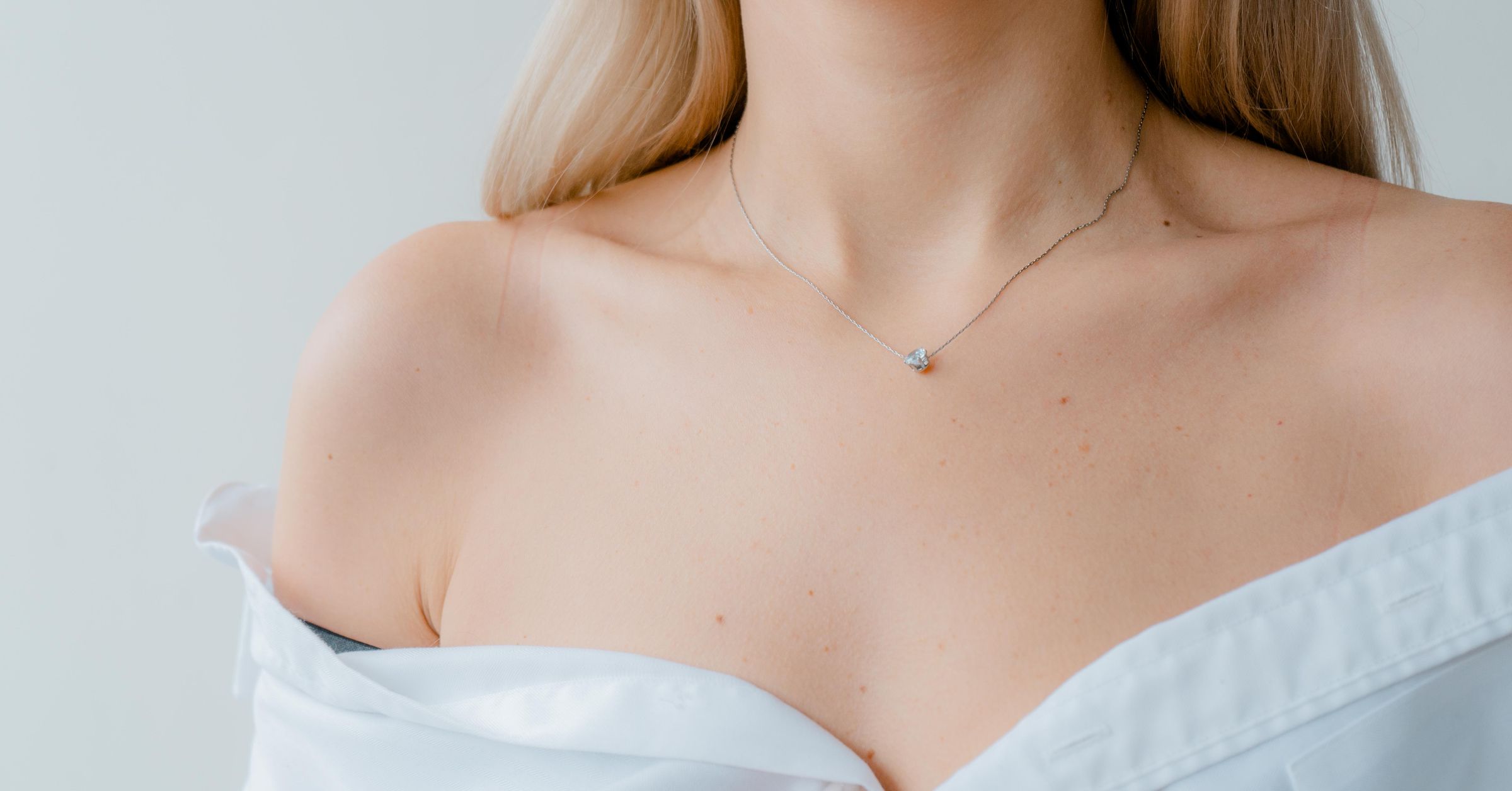 Detalhe de colo com colar de ponto de luz em ouro branco