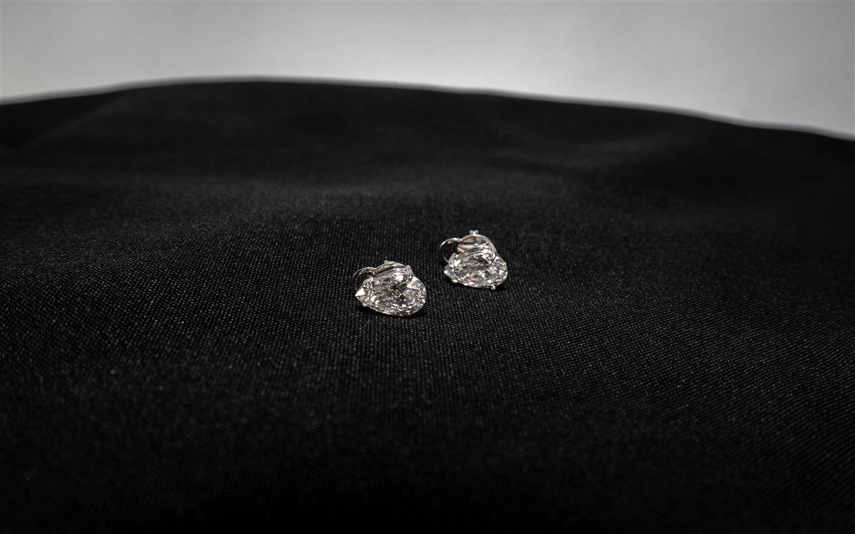 Brincos de diamante da ROCCA sobre tecido escuro, em luz dramática